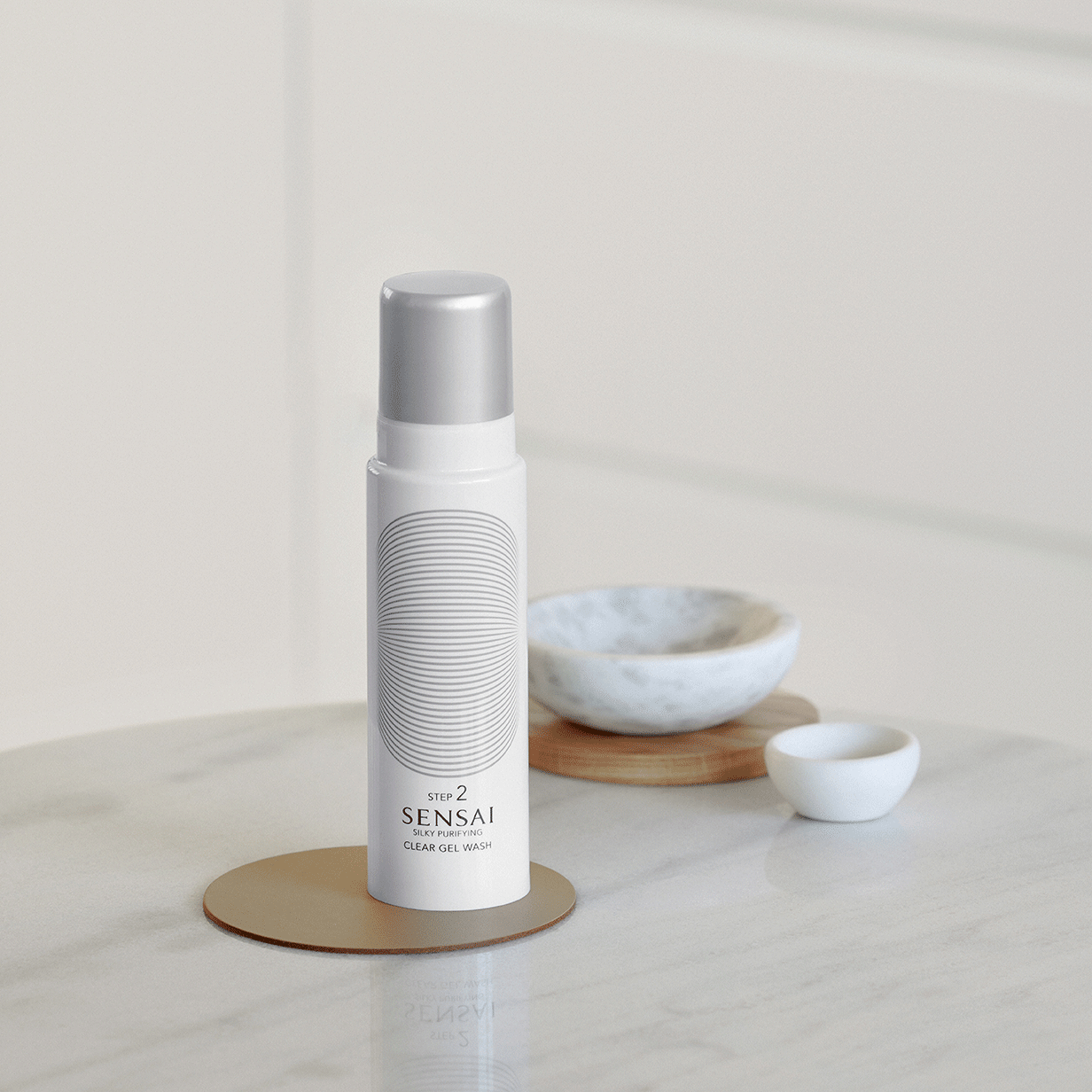 Prodotto Silky Purifying Clear Gel Wash SENSAI sul tavolo e texture sulla mano 